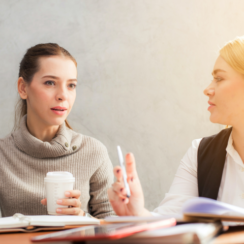 Zwei Frauen im Gesprch - sitzen an einem Tisch